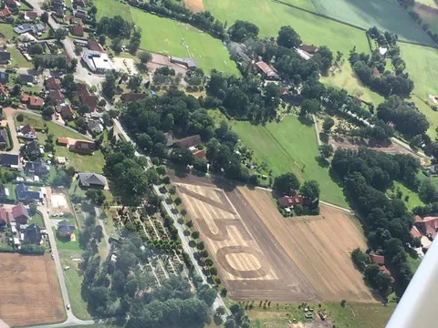 Luftbild von Varl aus einem Kleinflugzeug: zwischen den Feldern ist die Zahl 750 angelegt